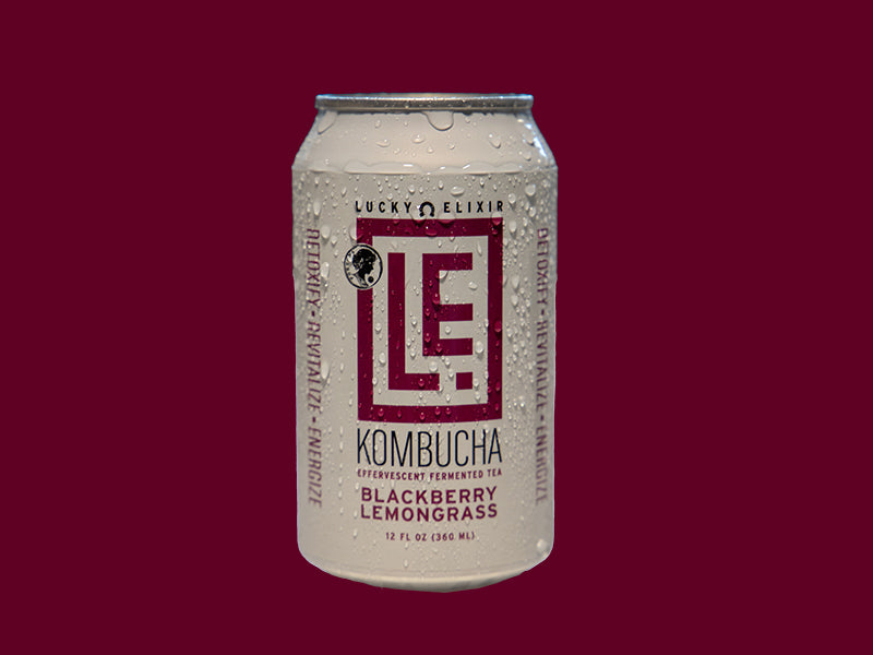 A can of Blackberry Lemongrass Kombucha by Lucky Elixir with condensation, on a dark red background.