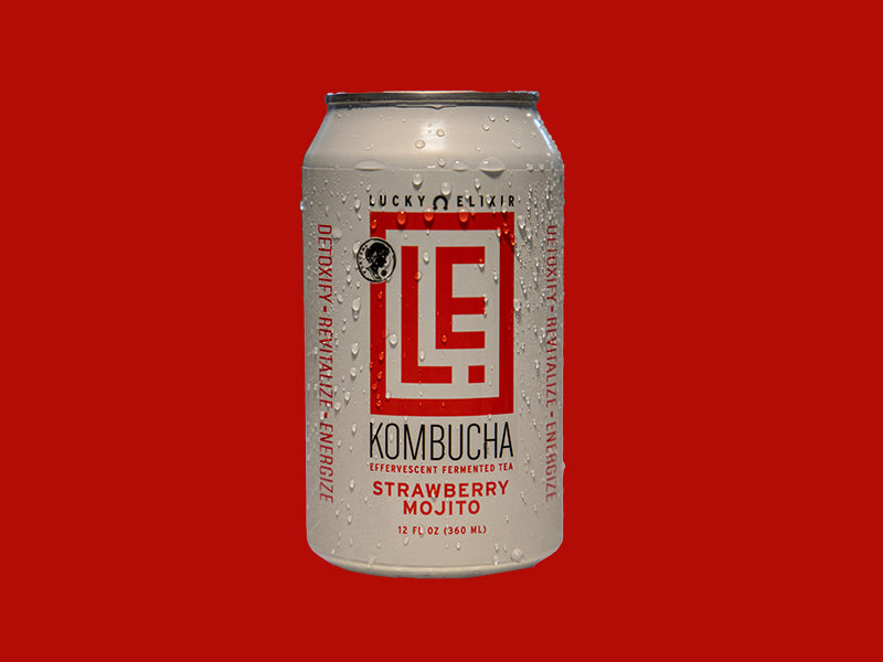 A can of Lucky Elixir Strawberry Mojito Kombucha with condensation, on a red background.