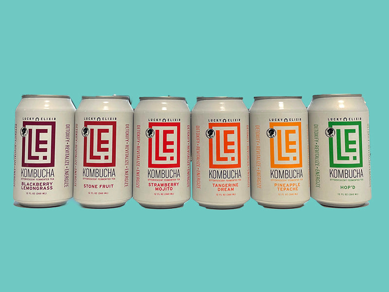 A variety of Kombucha tea cans in different flavors, including Hop&#39;d, Stone Fruit, Blackberry Lemongrass, Strawberry Mojito, Razzmatazz, and Ginger Lime.